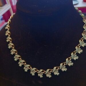 Silver and turquoise colored necklace and bracelet in a floral pattern.